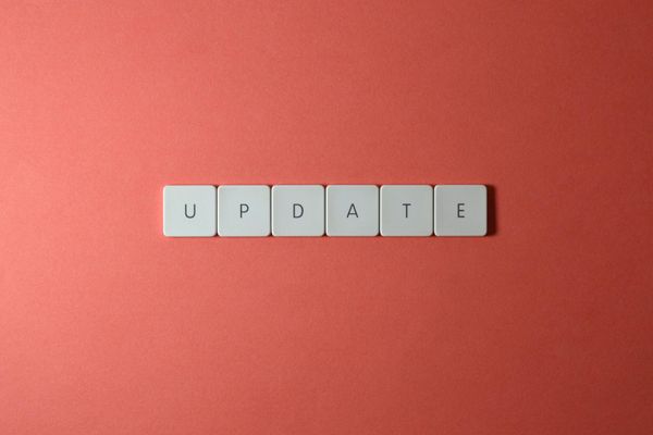 White letter tiles spelling "UPDATE" on coral background